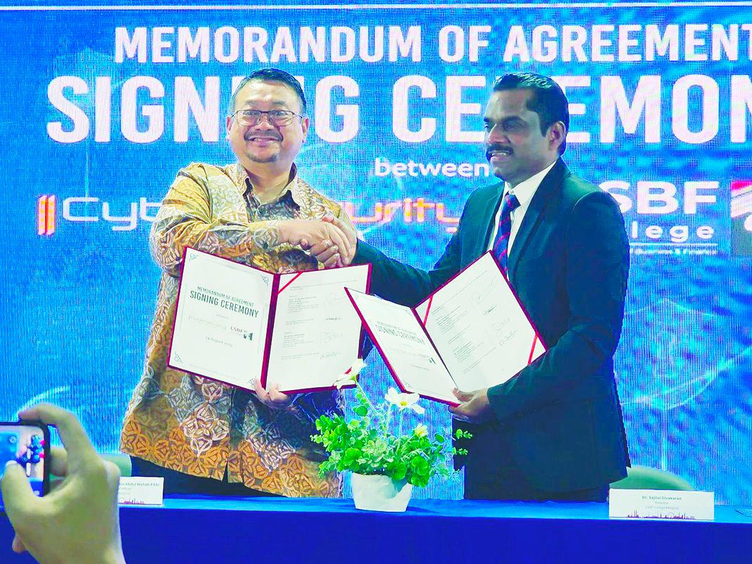 (left) Amirudin feels cybersecurity training is vital towards building a safe ecosystem for Malaysia, seen here with Dr Sajilal at MOA signing with LBSF,KL.