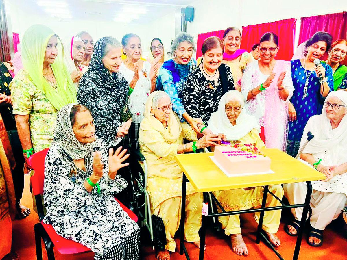Some elderly members of the community celebrating together by cutting a cake. - Credit: EKTA 2025