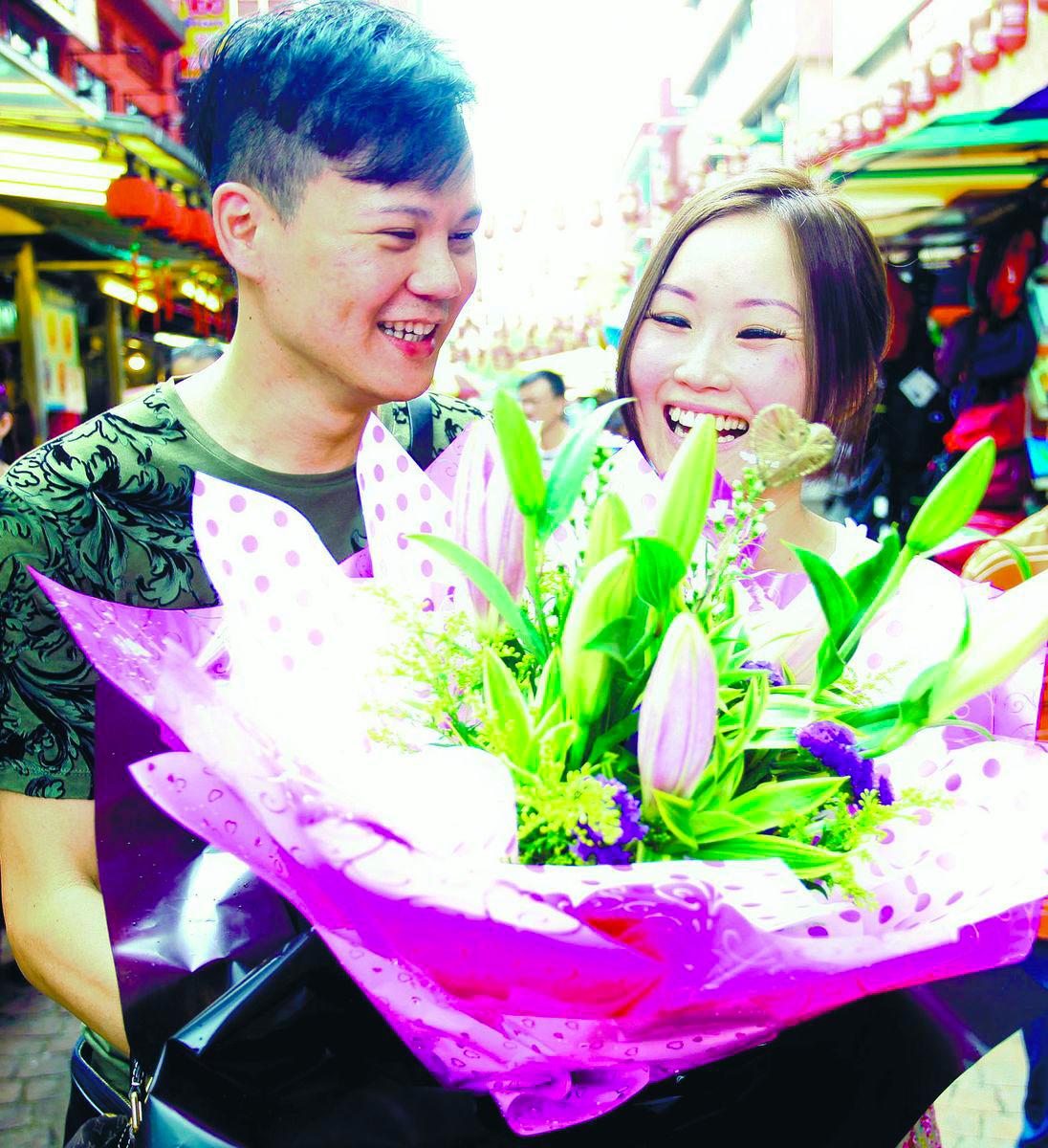 A woman giving a bouquet of flowers to her boyfriend in conjunction with Boyfriend Day. – Syed Azahar Syed Osman/theSun
