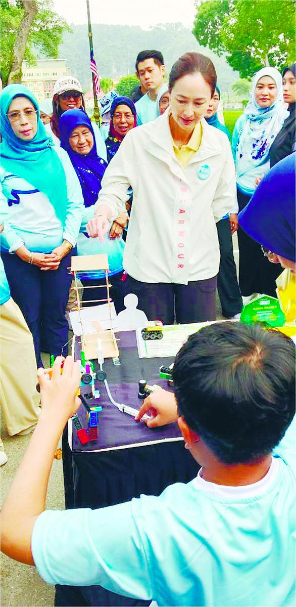 Tuanku Zara watching a boy with disability display his skills.