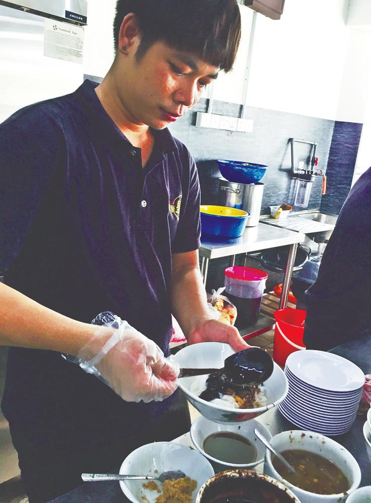 Staff preparing a bowl of Kon lou sabah noodles – TAN BEE HONG