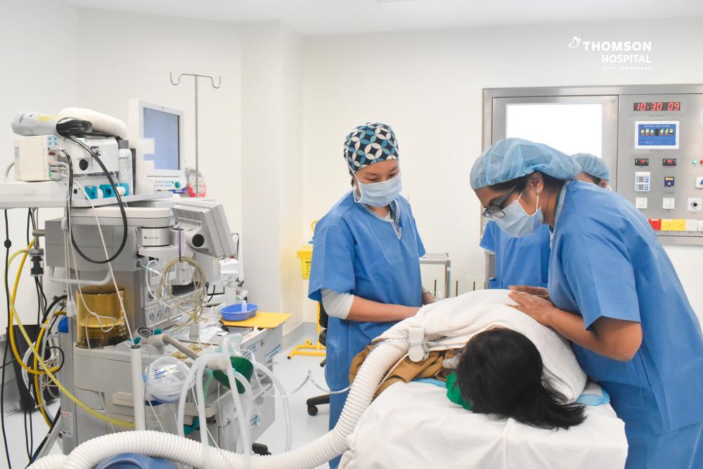 $!Dr Foo Sze Yuen, Consultant Paediatric Anaesthesiologist and Dr Sangita Dharshini Terumalay, Consultant Paediatrician &amp; Paediatric Neurologist with the patient.