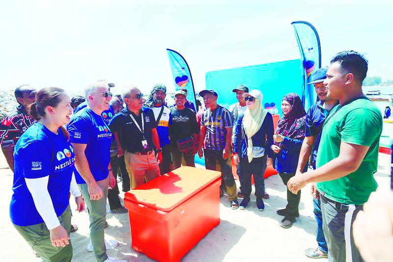 $!Aranols (2nd from left) presenting essential fishing supplies and equipment to the local fishing community.