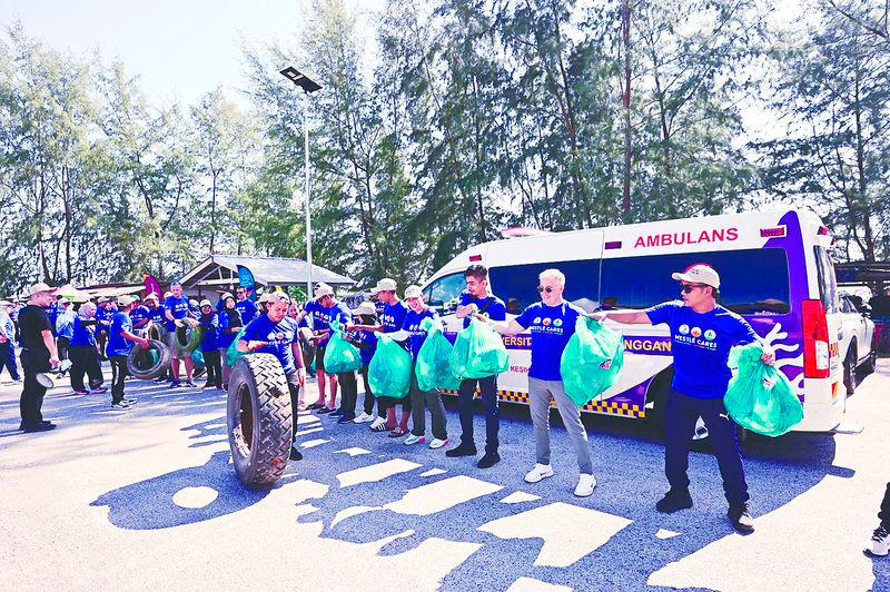 $!Volunteers form a line to channel collected marine waste to a designated point for weighing and sorting, following a successful cleanup at Pantai Tok Jembal.