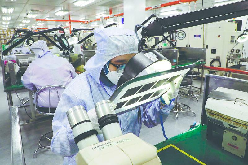 A worker inspects semiconductor chips at a chip packaging firm in Ipoh, Malaysia. – REUTERSPIC