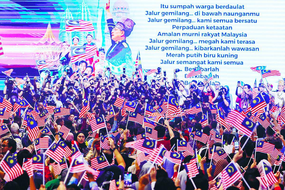 The act of waving the flag expresses a collective heartbeat of unity. – BERNAMAPIC