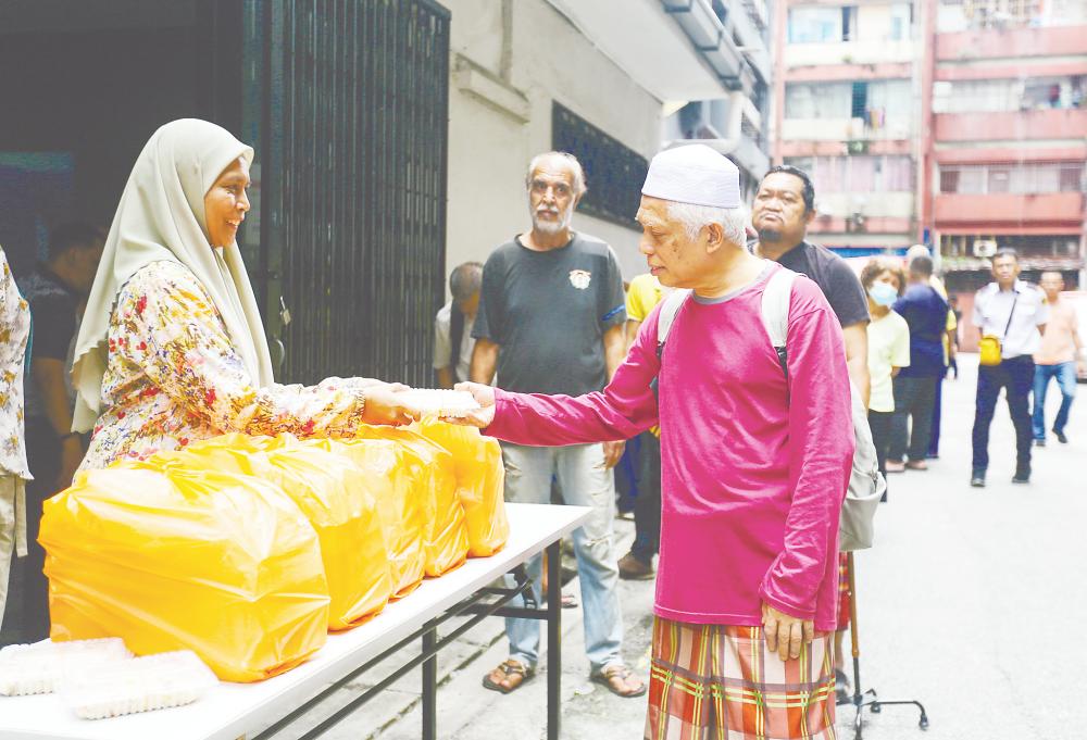 Noralina at a station during one of the food distribution drives. – Adam Amir Hamzah/theSun