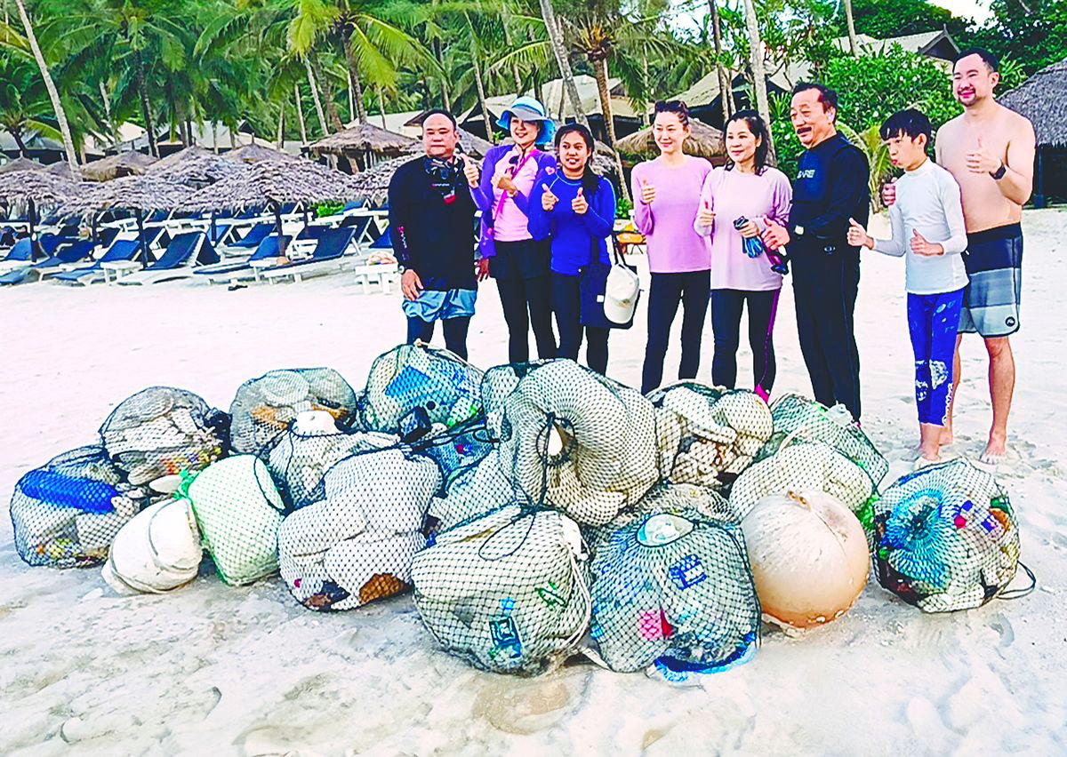 Tan (third right) beside Esther during the beach cleanup. – Pic courtesy of Berjaya Group