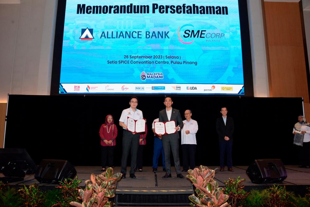 Alliance Bank Group chief strategy, marketing &amp; business development officer Dr Aaron Sum Wei Wern (front, right) and Rizal holding up the signed MoU documents.