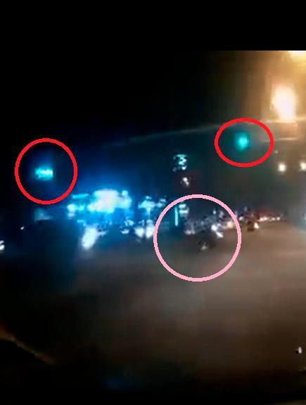 $!Footage from the Myvi’s dashcam shows the green traffic lights (in red circles) and the rider (in pink circle). – Facebook/@DashCam Owner Malaysia