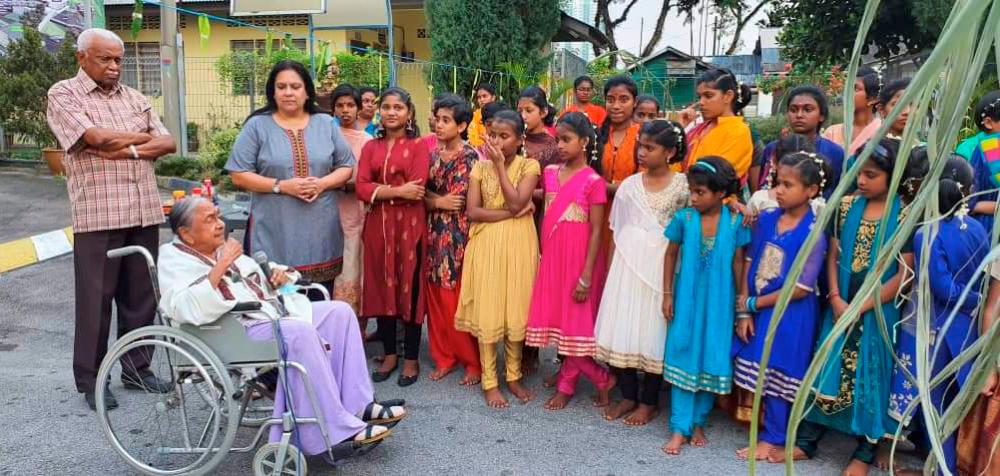 Mangalam addressing a group of children during a Ponggal event.