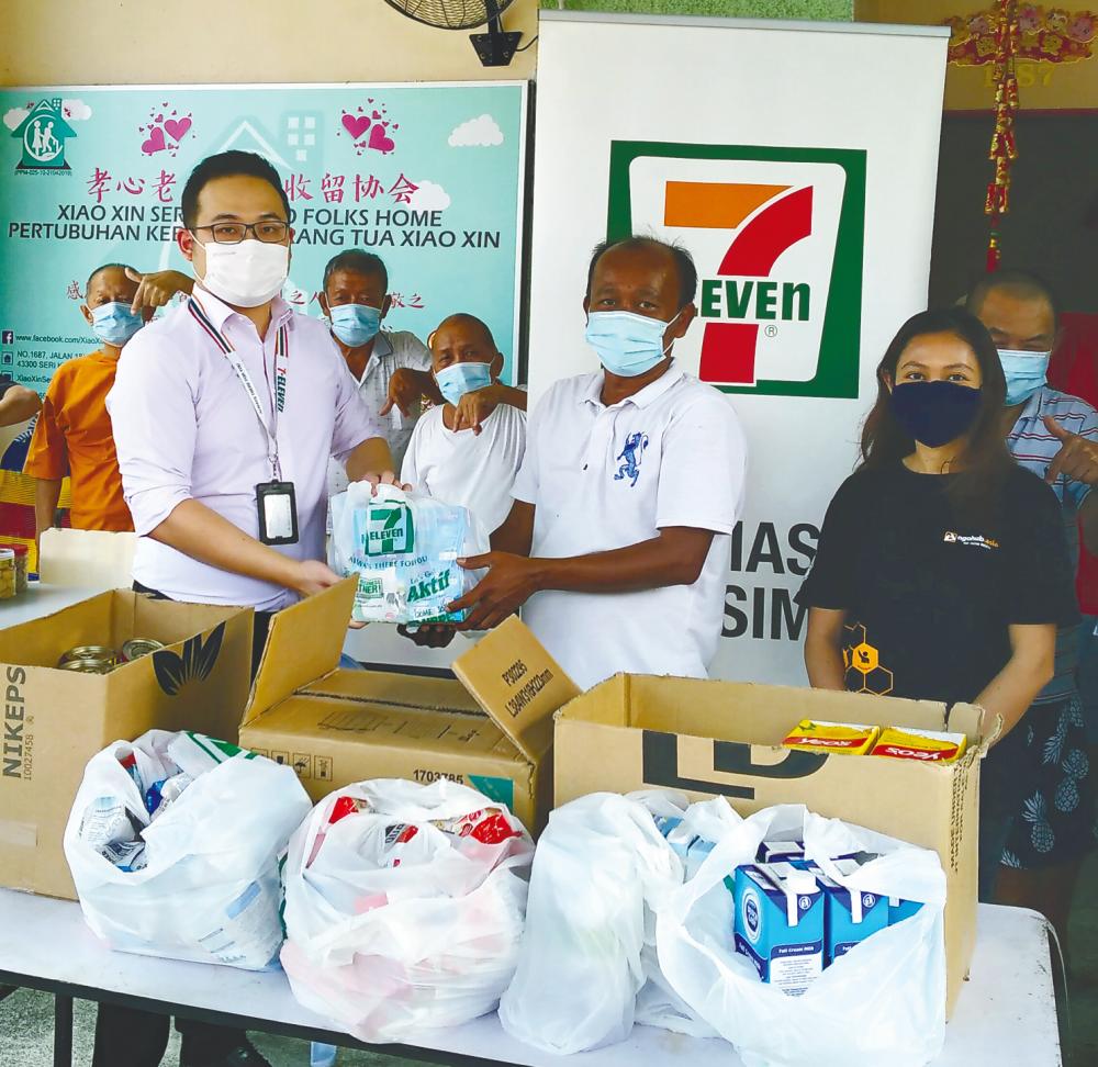 7-Eleven Malaysia’s representative (left) and NGOhub’s representative (right) handing over essential items and food supplies to a representative of Pertubuhan Kebajikan Orang Tua Xiao Xin.