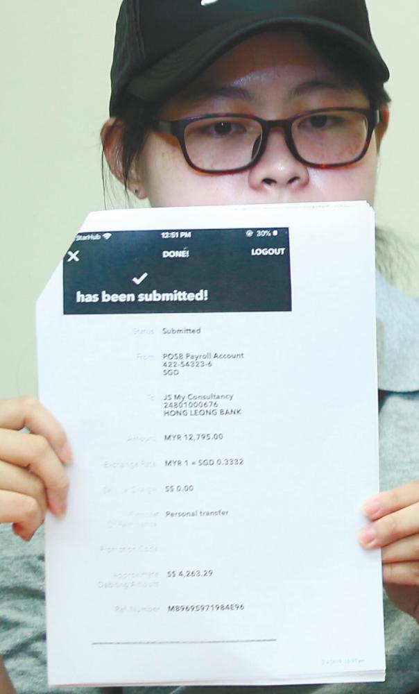 Lim holding up the proof of payments amounting to RM12,800 at a press conference at the office of MCA Public Complaints and Bureau head Datuk Seri Michael Chong in Kuala Lumpur on May 14, 2019. — BBX