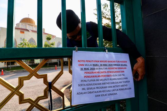 $!A mosque caretaker locking up the main gate of Bandar Tun Hussein Onn Mosque which is closed for worship activities following a Restriction of Movement Order announced by Prime Minister Tan Sri Muhyiddin Yassin on Monday as preventive measure to combat the spread of Covid-19. Zahid IZZANI / THE SUN