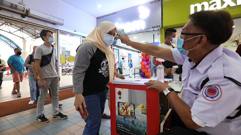 $!A customer’s temperature being taken at the entrance of the Pandan Capital Mall yesterday. – HAFIZ SOHAIMI/THESUN