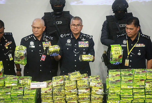 Inspector-General of Police (IGP) Tan Sri Mohamad Fuzi Harun shows off the drugs seized during raids in Perak and Johor over the weekend at a press conference at Bukit Aman police headquarters on Jan 14, 2019. — Sunpix by Amirul Syafiq Mohd Din