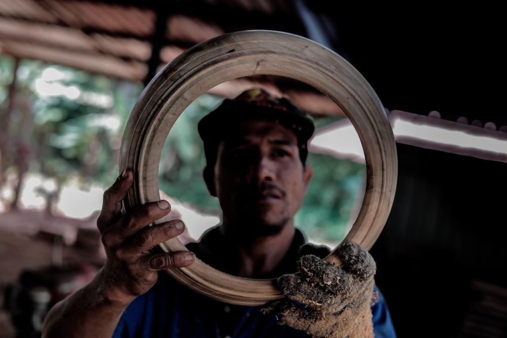 $!A worker checks the frame of the kompang for any cracks or flaws.