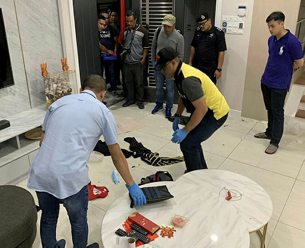 A bomb disposal unit inspects a suspected explosive device at a house on Jalan Bukit Gambir, Jelutong, last night.