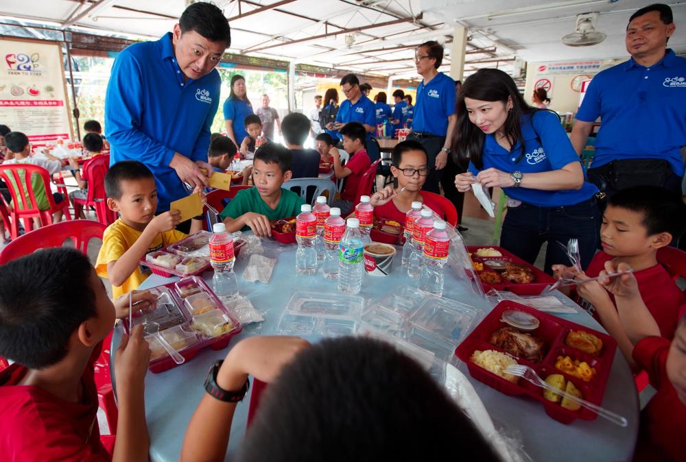 BCorp CEO Datuk Seri Robin Tan (L) distributing red packets to children at House Of Love during the company’s CSR programme in Klang on March 29, 2019. — Sunpix by Norman Hiu
