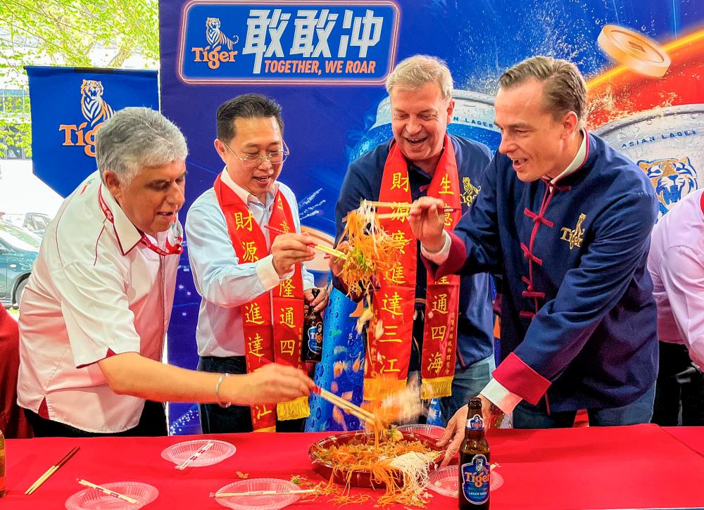 $!Leaders tossing yee sang together, symbolising hopes for prosperity and unity.