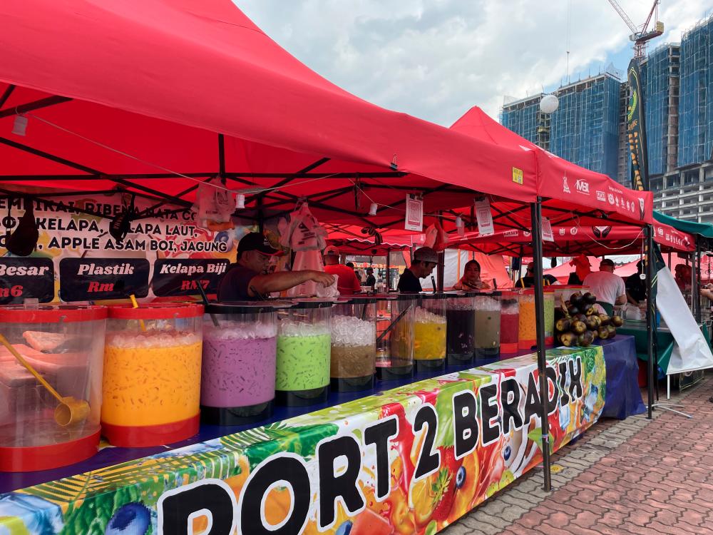 A vendor selling a colourful selection of drinks, perfect for breaking fast.