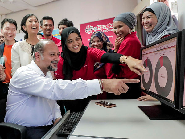 Communications and Multimedia Minister Gobind Singh Deo (seated), at a Rural Internet Centre (PID) after launching the Localised eDagang Services (Pedas) at Kajang today. — Sunpix by Ashyraf Shamsul