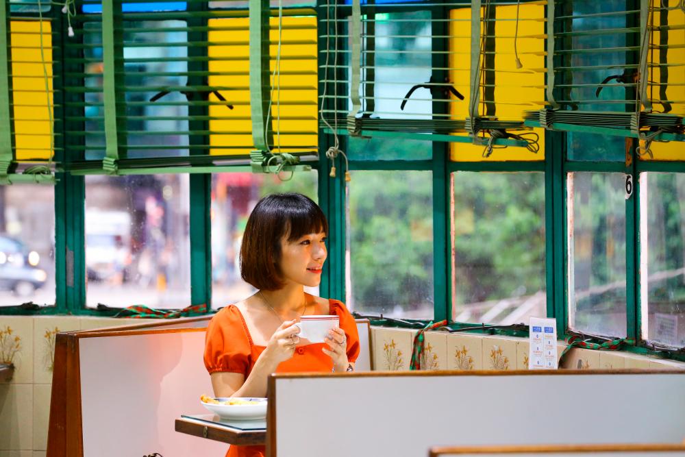 $!Malaysian actress and Hong Kong Superfan Koe Yeet enjoying her favourite Hong Kong milk tea at Mido café whilst experiencing the nostalgic vibes of Mido’s well-worn coloured windows, mosaic tiles, and ceiling fans.