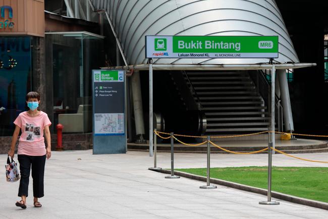 $!A woman passing by a rare sights of an empty street of Bukit Bintang Monorail Line in Kuala Lumpur following a Restriction of Movement Order announced by Prime Minister Tan Sri Muhyiddin Yassin on Monday as preventive measure to combat the spread of Covid-19. - HAFIZ SOHAIMI/THESUN