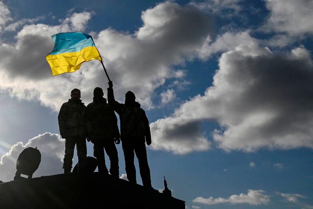 Ukrainian personnel hold a Ukrainian flag as they stand on a Challenger 2 tank during training at Bovington Camp, near Wool in southwestern Britain, February 22, 2023. REUTERS/Toby Melville/File Photo