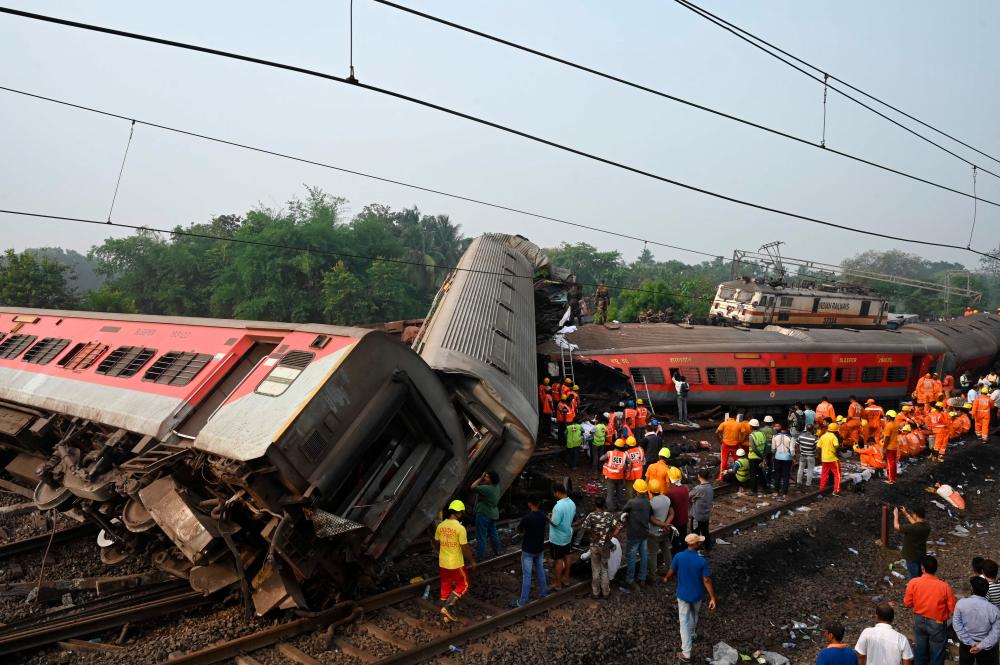 Rescue workers gather around damaged carriages during search for survivors at the accident site of a three-train collision near Balasore, about 200 km (125 miles) from the state capital Bhubaneswar in the eastern state of Odisha, on June 3, 2023/AFPPix