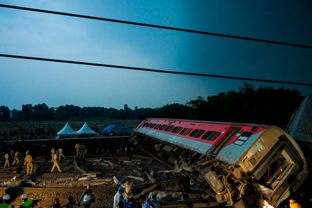 Policemen inspect the accident site of carriage wreckage of a three-train collision near Balasore, in India’s eastern state of Odisha, on June 3, 2023/AFPPix
