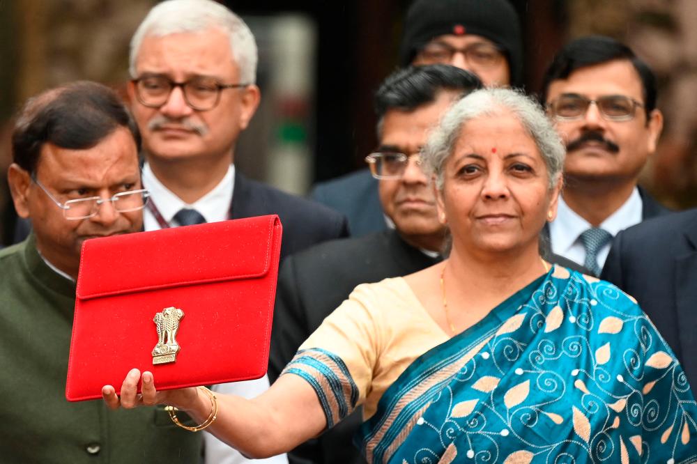 India’s Finance Minister Nirmala Sitharaman (R) along with her staff poses for pictures as she leaves the Finance Ministry Office to present the annual budget in parliament in New Delhi on February 1, 2024/AFPPix