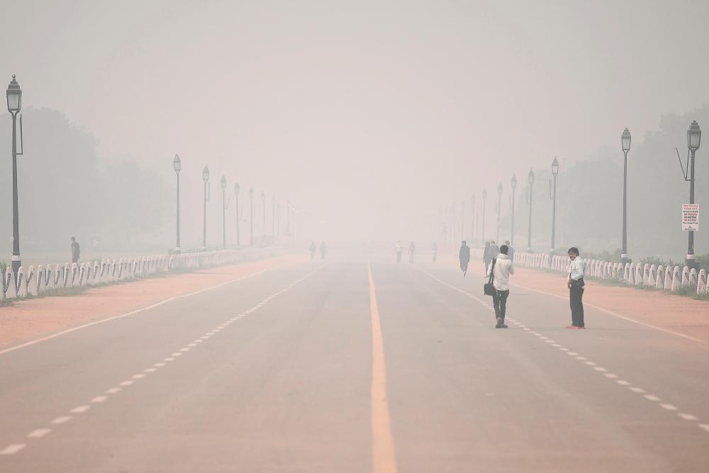 People walk along Rajpath near India Gate under heavy smog conditions in New Delhi on November 9, 2020. AFPPIX/FILEPIX