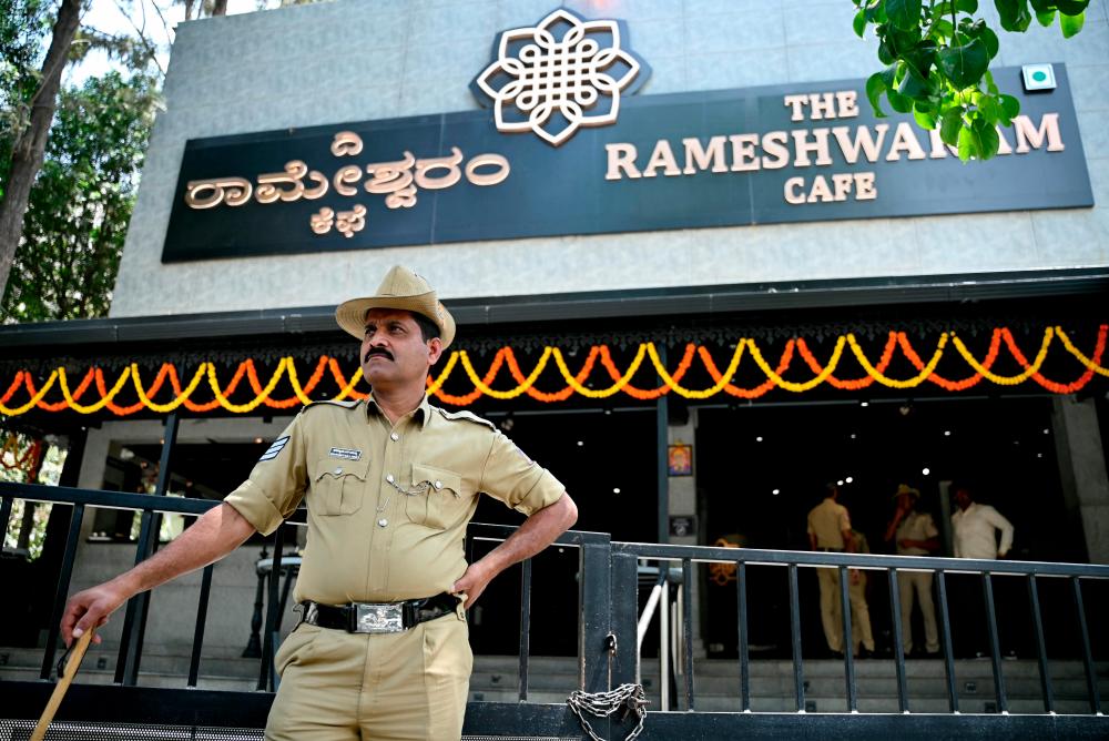 A police personnel stands guard near the site of a bomb blast at Rameshwaram Cafe in Bengaluru on March 2, 2024. - AFPPIX