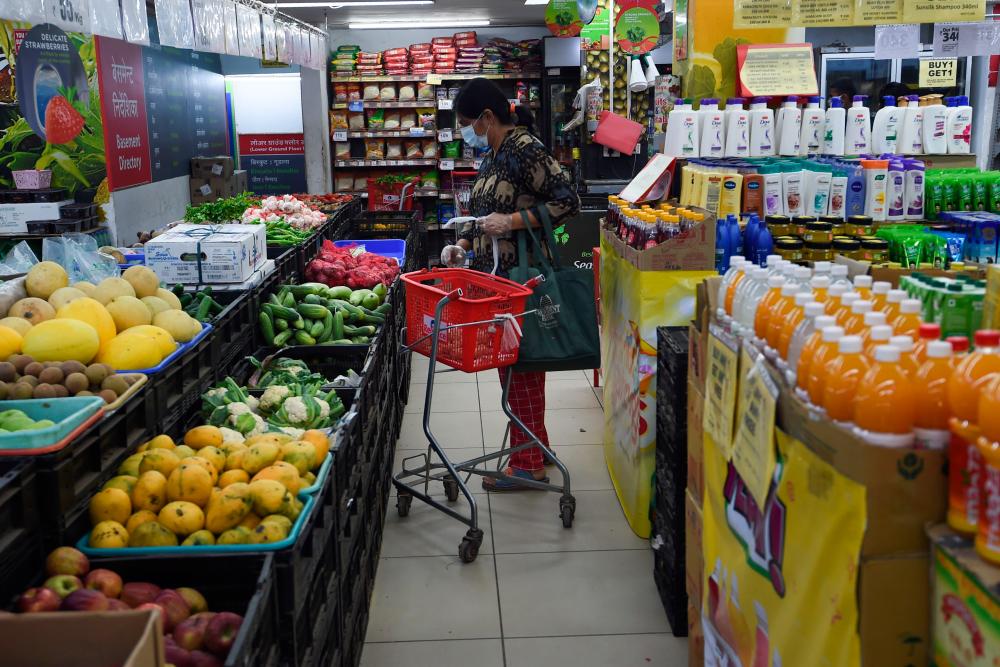 A woman buys groceries at a store during the first day of a 21-day government-imposed nationwide lockdown as a preventive measure against the Covid-19 coronavirus in Faridabad in the state of Haryana on March 25, 2020. - AFP