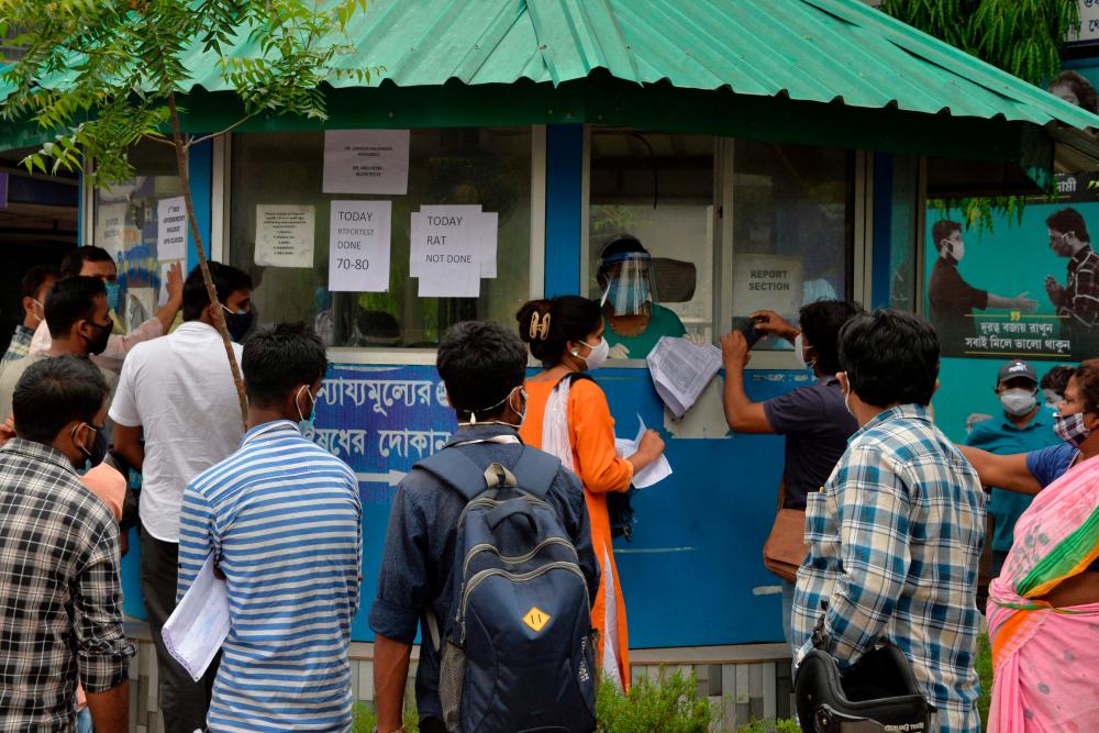 People wait to be tested for the Covid-19 coronavirus outside Siliguri district hospital in Siliguri on May 4, 2021. –AFP