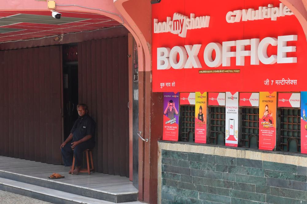 $!n this picture taken on June 18, 2020, a security guard sits at the entrance of a closed movie theatre complex due to a COVID-19 coronavirus lockdown in Mumbai. / AFP / INDRANIL MUKHERJEE