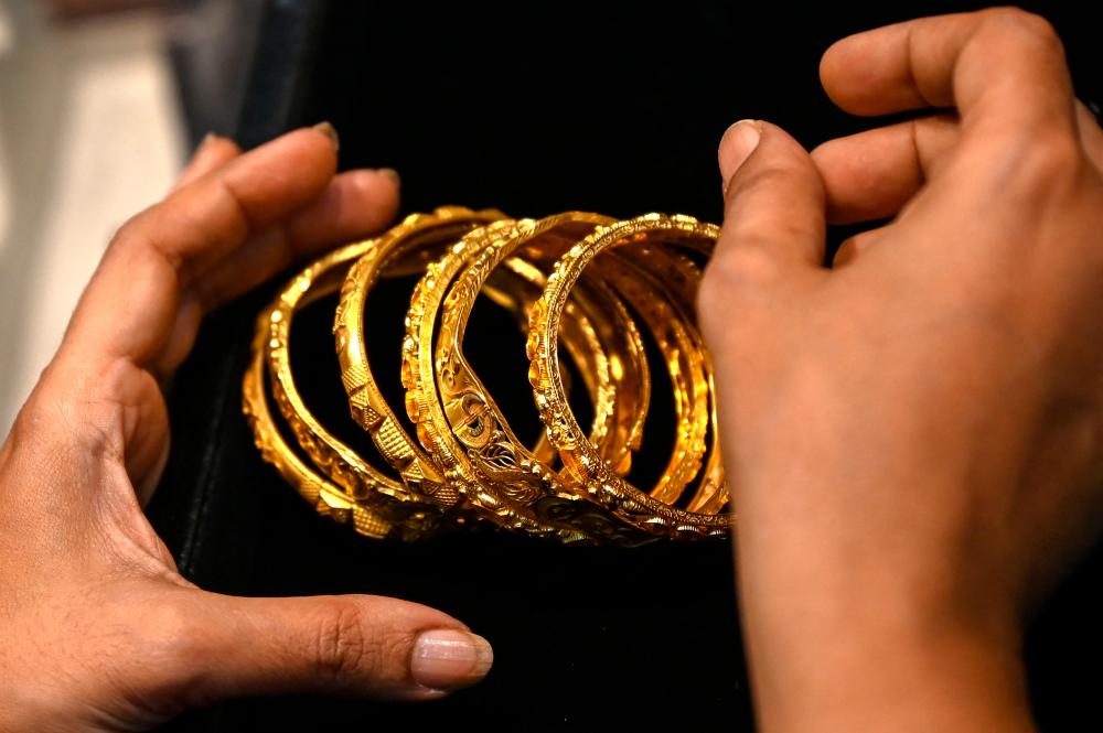 This picture taken on August 11, 2021 shows a customer handling gold bracelets at a jewellery shop in Mumbai. AFPpix