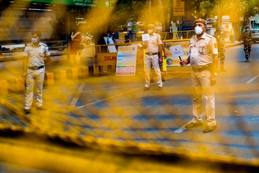 Policemen guard a roadblock in New Delhi on April 20, 2021, as India locked down its capital for a week beginning April 19 seeking to control a raging coronavirus outbreak. –AFP
