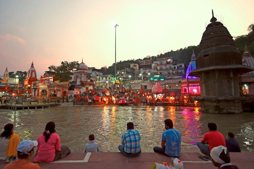 In this picture taken on June 11, 2020, Hindu devotees attend evening prayers at Har Ki Pauri ghat on the banks of the river Ganges, after the government eased a nationwide lockdown imposed as a preventive measure against the COVID-19 coronavirus at Haridwar in Uttarakhand state. / AFP / Money SHARMA