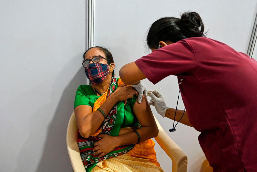A woman gets inoculated with a dose of the Covishield, AstraZeneca-Oxford’s Covid-19 coronavirus vaccine, at a vaccination centre in Mumbai in Mumbai on April 9, 2021. - AFP
