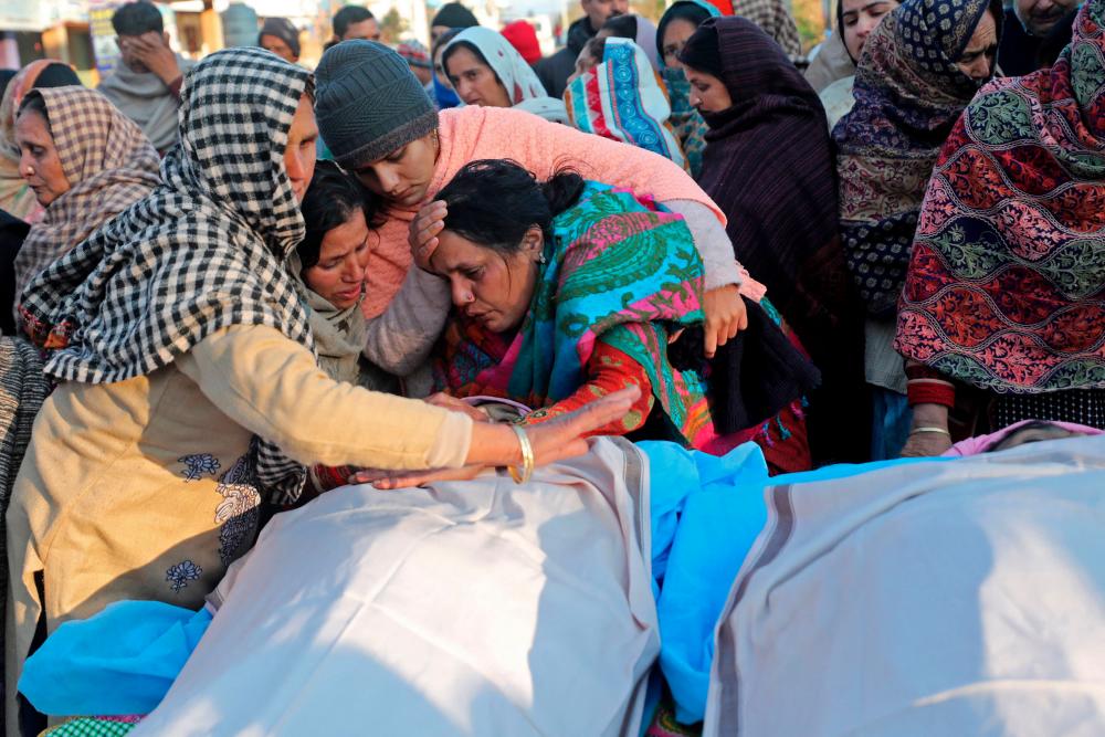 Graphic content / Family members mourn next to the bodies of residents who were killed after two gunmen suspected to be anti-India rebels opened fire on houses in the remote village of Dangri in Rajouri district on January 2, 2023. AFPPIX