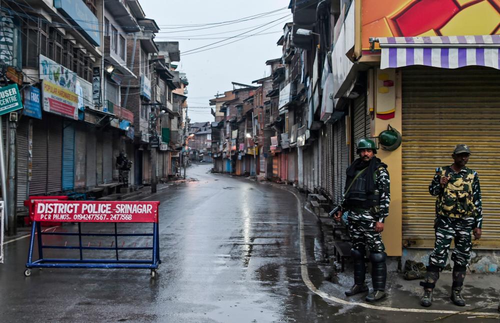 Security personnel stand guard during a lockdown in Srinagar on Aug 14, 2019, after the Indian government stripped Jammu and Kashmir of its autonomy. — AFP