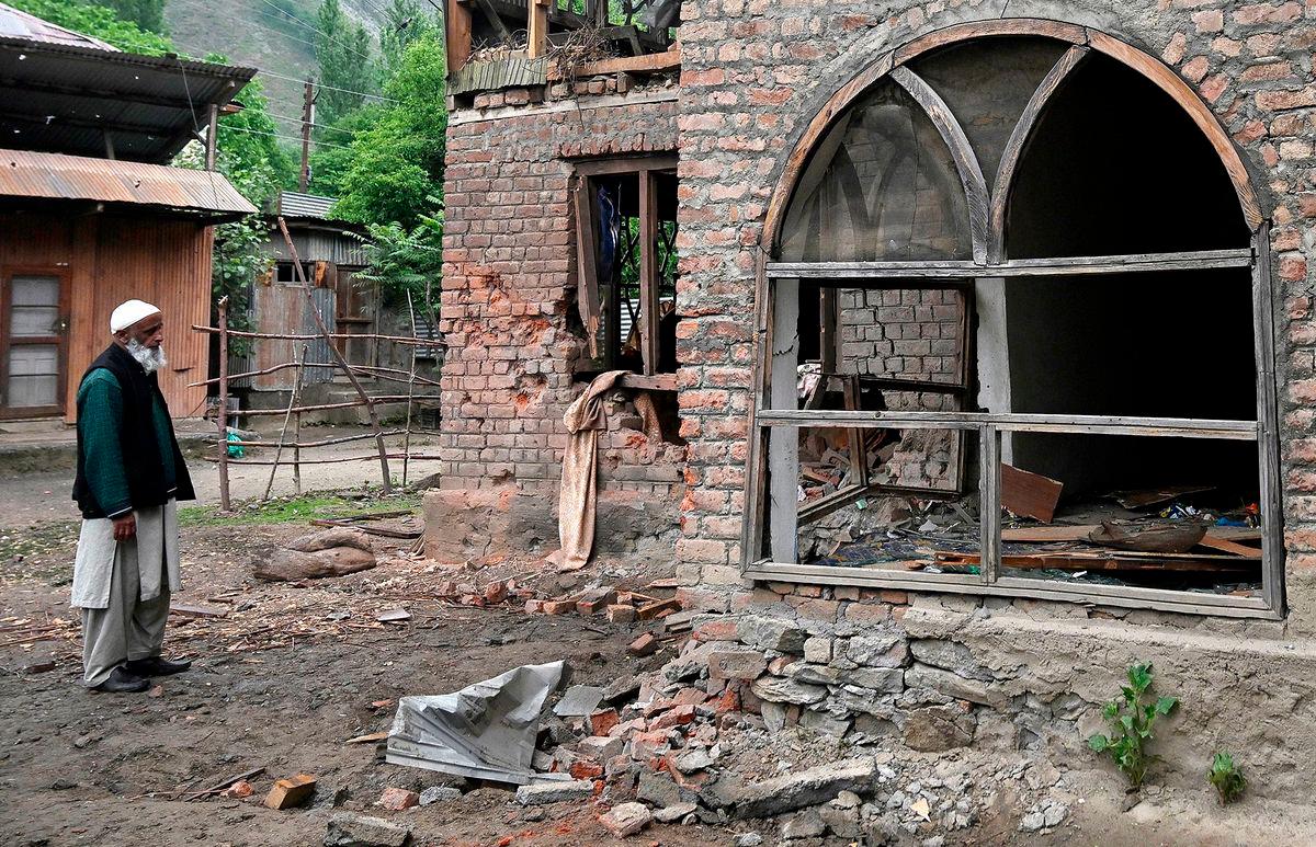 A local resident inspects his house that - AFPPIX
