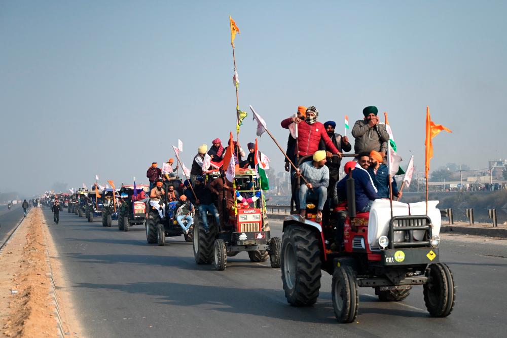 Farmers take part in a tractor rally as they continue to demonstrate against the central government’s recent agricultural reforms in New Delhi on January 26, 2021. / AFP / Money SHARMA