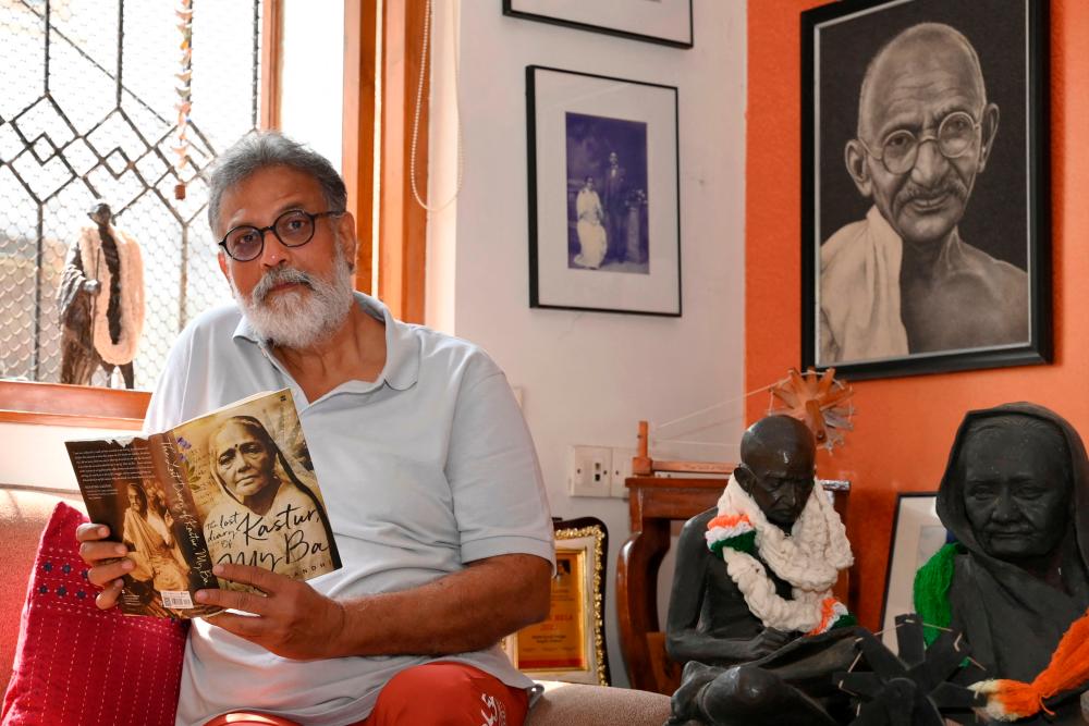In this picture taken on January 25, 2023, Indian author Tushar Gandhi, the great grandson of Mahatma Gandhi, reads a book during an interview at his home in Mumbai. AFPPIX