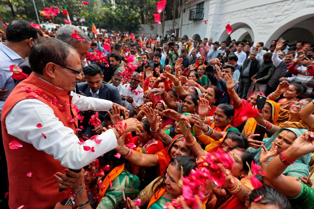 Chief Minister of Madhya Pradesh and member of Bharatiya Janata Party (BJP) Shivraj Singh Chouhan (2L) is greeted by his supporters at his residence in Bhopal on December 3, 2023, following BJP's victory at the Madhya Pradesh assembly elections. - AFPPIX