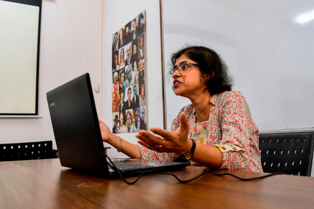 In this photograph taken on March 12, 2021, Lorraine Alberto, professor of Portuguese language at Goa University, speaks to her students during an online class at Panaji in Goa. -AFP