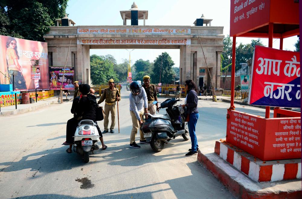 Security personnel check motorists at a roadblock in Ayodhya on November 10, 2019, after Supreme Court's verdict on a disputed religious site. - AFP