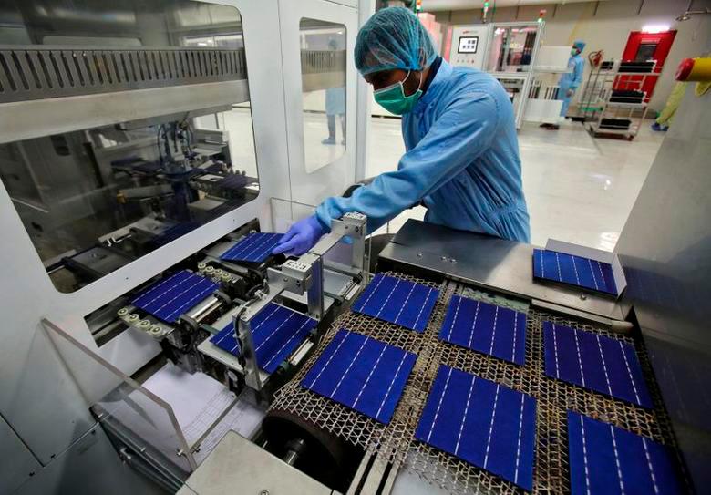 An employee on a solar cell production line at a factory in Himachal Pradesh, India. The country aims to cut imports and boost local manufacturing of solar modules and cells. – REUTERSPIX